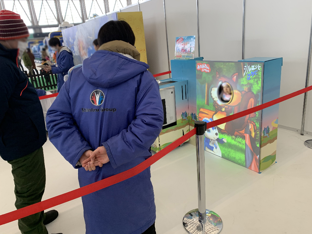 かおだしデジタルパネルの画面と体験者 (雪まつり2020)