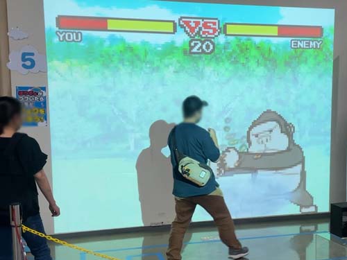 動物とジャンプ力を競い、体を動かす子供たち