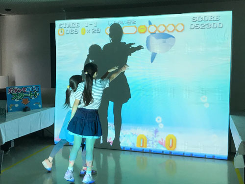 カラフルな深海魚をゲットしようとジャンプする子供